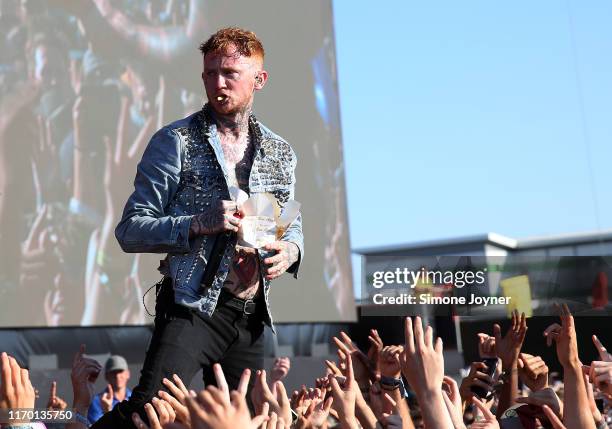 Frank Carter of Frank Carter & The Rattlesnakes eats some chips he was given by a fan as he performs live on the Main Stage during day three of...