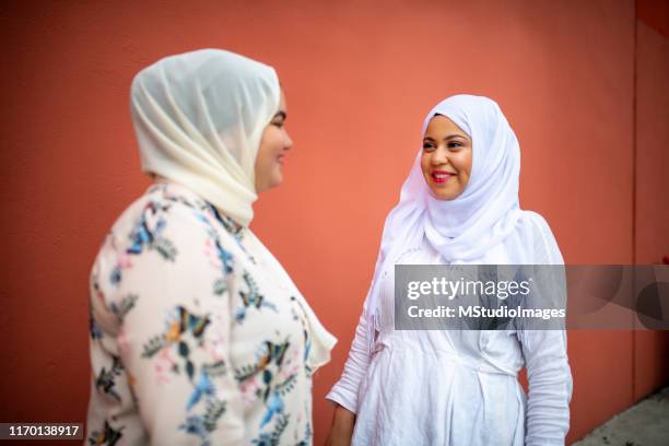two muslim friends laughing. - headscarf stock pictures, royalty-free photos & images