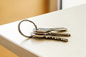 Set of three house keys on the ring on table in a room. Bunch of apartment keys close-up. To forget keys at home consept.
