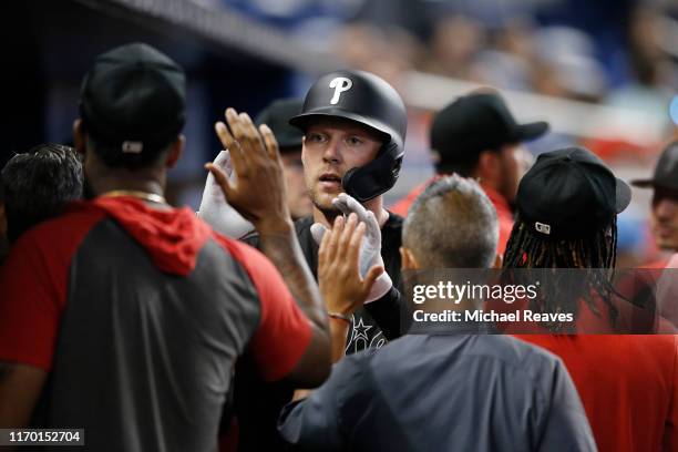 Rhys Hoskins of the Philadelphia Phillies celebrates with teammates after hitting a two-run home run in the sixth inning against the Miami Marlins at...