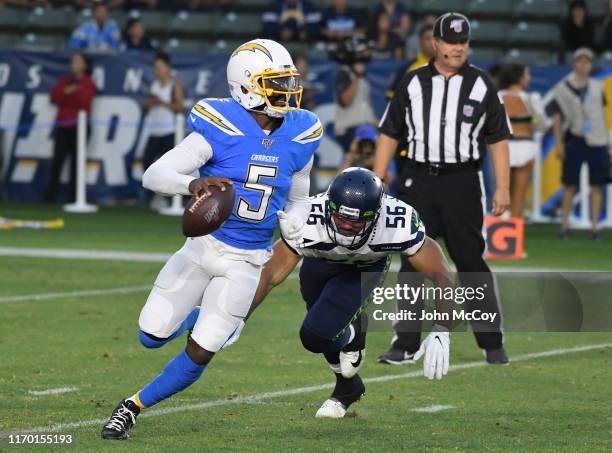 Tyrod Taylor of the Los Angeles Chargers avoids Mychal Kendricks of the Seattle Seahawks during a preseason NFL football game at Dignity Health...