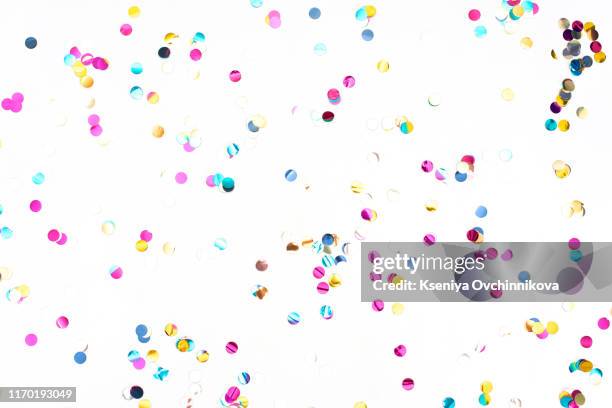 colourful sparlking confetti on white background - konfetti stock-fotos und bilder