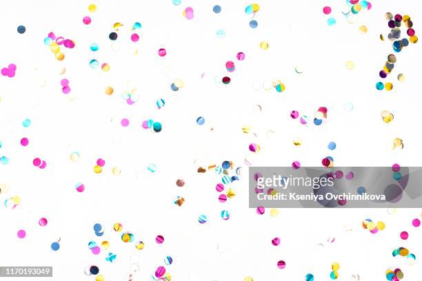 colourful sparlking confetti on white background - coriandoli foto e immagini stock