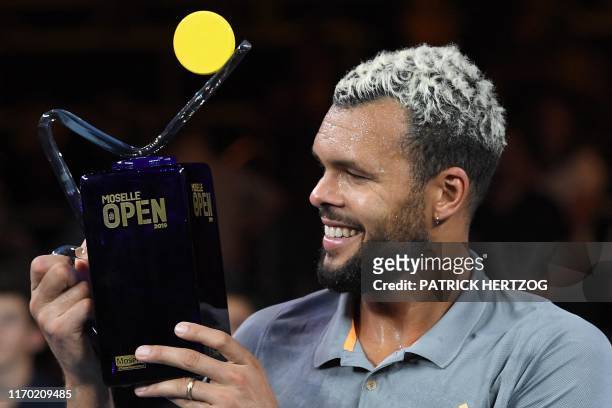 French tennis player Jo-Wilfried Tsonga celebrates with the winner's trophee after winning the ATP Moselle Open final tennis match against Slovenia's...
