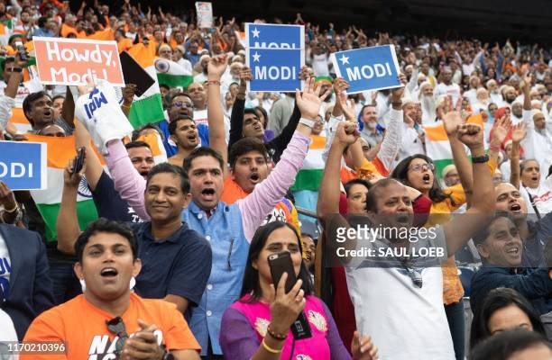 People cheer as US President Donald Trump and Indian Prime Minister Narendra Modi attend "Howdy, Modi!" at NRG Stadium in Houston, Texas, September...