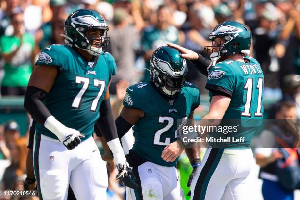 Andre Dillard, Jordan Howard, and Carson Wentz of the Philadelphia Eagles react after a touchdown run by Howard in the first quarter against the...