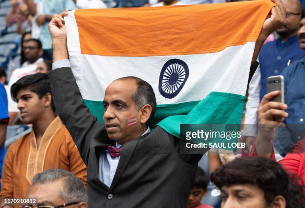 Man holds up the falg of India as US President Donald Trump and Indian Prime Minister Narendra Modi attend "Howdy, Modi!" at NRG Stadium in Houston,...