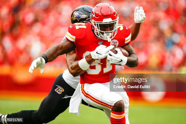 Darrel Williams of the Kansas City Chiefs runs after a catch while being tackled by Kenny Young of the Baltimore Ravens at Arrowhead Stadium on...