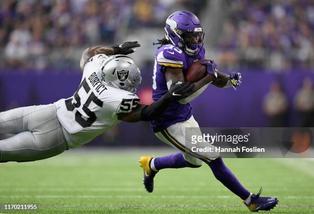 Dalvin Cook of the Minnesota Vikings avoids a tackle by Vontaze Burfict of the Oakland Raiders during the second quarter of the game at U.S. Bank...