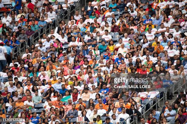 Attendees listen as US President Donald Trump and Indian Prime Minister Narendra Modi attend "Howdy, Modi!" at NRG Stadium in Houston, Texas,...