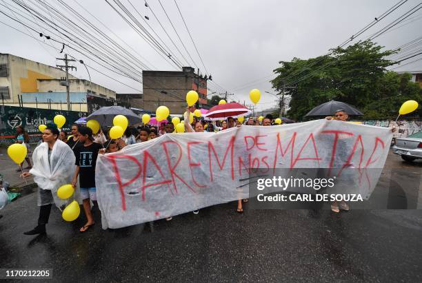Protestors make their way to the funeral of eight-year-old Agatha Sales Felix, who was killed by a stray bullet during a police operation at the...