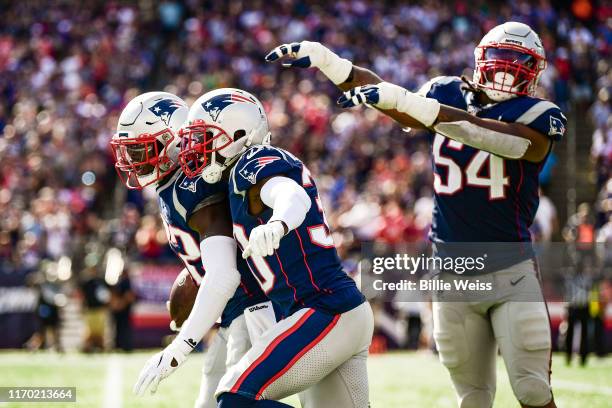 Devin McCourty of the New England Patriots reacts with Jason McCourty after intercepting a pass during the third quarter of a game against the New...