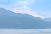 A boat sailing in Ashinoko lake with snow cap Fuji mountain (Fujisan) , Hagone