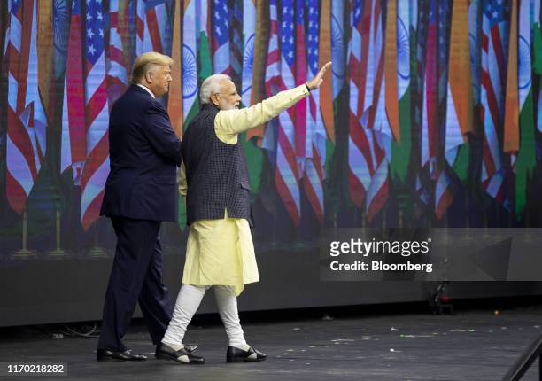 Narendra Modi, India's prime minister, left, and U.S. President Donald Trump hold hands on stage during the Howdy Modi Community Summit in Houston,...