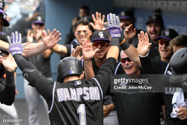 Garrett Hampson of the Colorado Rockies celebrates in the dugout after his first inning home run against the Los Angeles Dodgers at Dodger Stadium on...