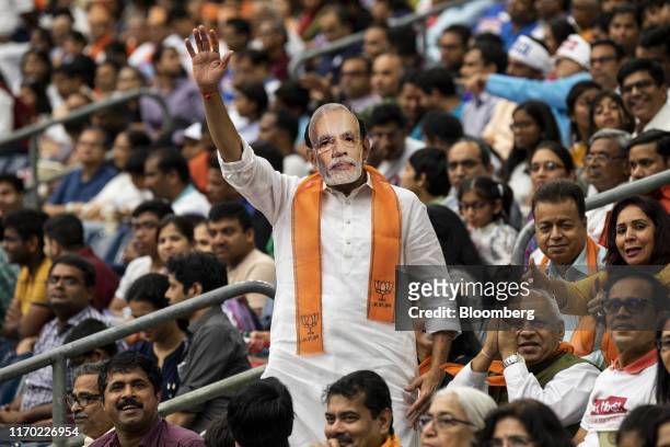 An attendee wears a mask in the likeness of Indian Prime Minister Narendra Modi at the Howdy Modi Community Summit in Houston, Texas, U.S., on...