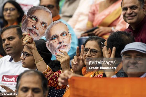 An attendee holds masks in the likeness of Indian Prime Minister Narendra Modi at the Howdy Modi Community Summit in Houston, Texas, U.S., on Sunday,...