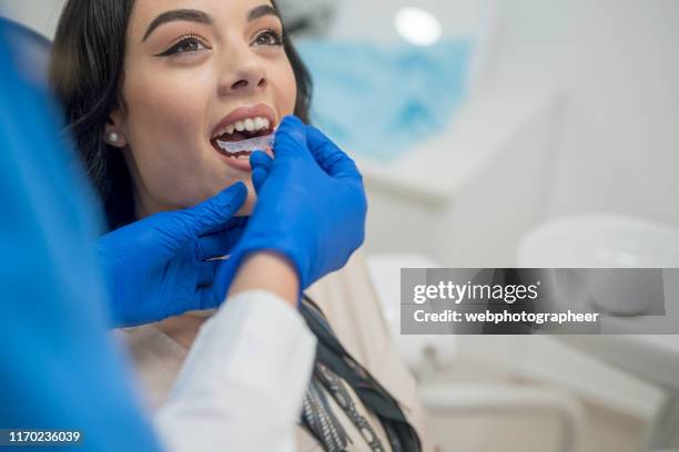 dentist inserting retainers - braces and smiles stock pictures, royalty-free photos & images