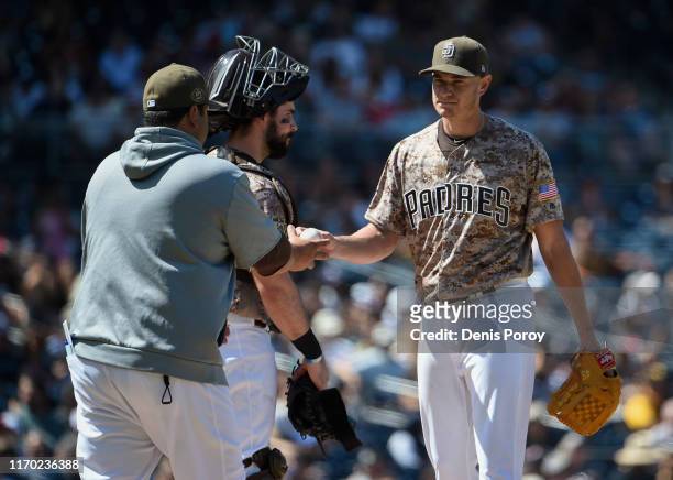 Garrett Richards of the San Diego Padres gives up the ball as he's taken out of the game by Rod Barajas during the second inning of a baseball game...