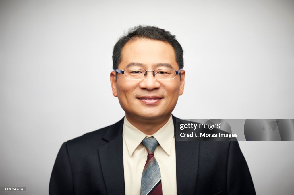 Confident businessman against white background