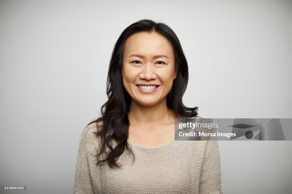 Smiling young woman against white background
