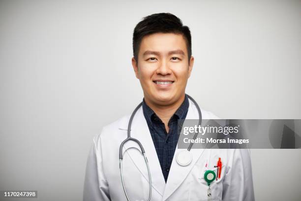 portrait of confident male doctor in lab coat - asiatischer mann freigestellt stock-fotos und bilder