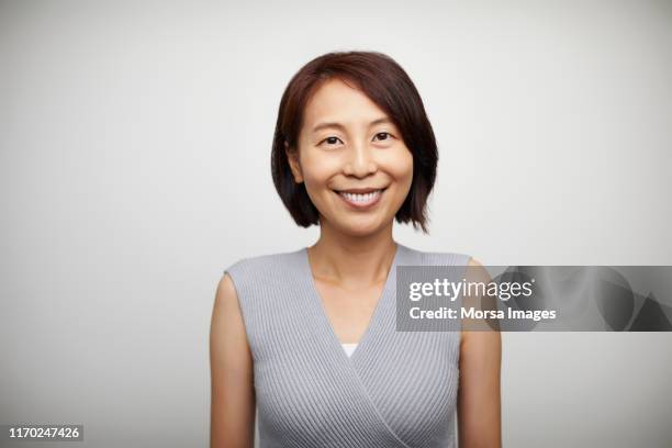 portrait of smiling mature woman in casuals - mature women portrait asian stock pictures, royalty-free photos & images