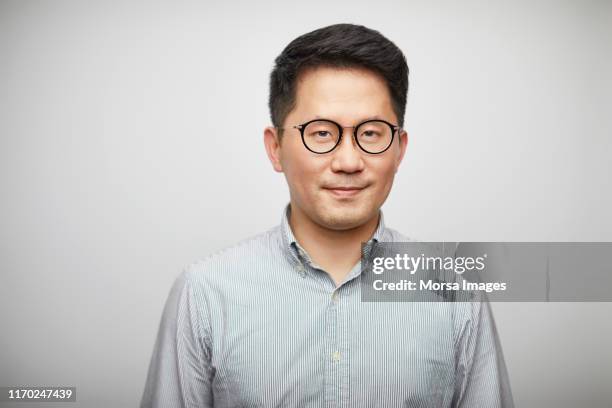 portrait of mid adult man against white background - gray shirt stock pictures, royalty-free photos & images