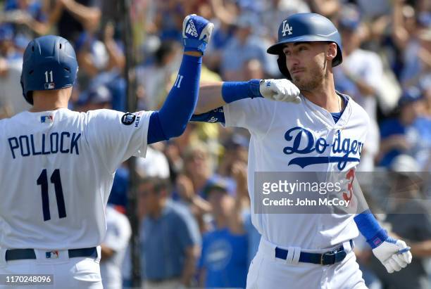 Pollock of the Los Angeles Dodgers congratulates Cody Bellinger for his grand slam home run against the Colorado Rockies in the fifth inning at...