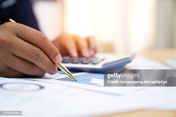 businessman analyzing investment charts with calculator, accounting,account,accounting concept - investment strategy concept stock pictures, royalty-free photos & images