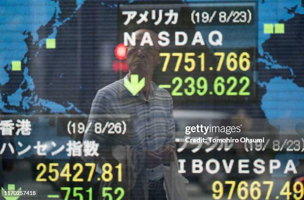 Man is reflected in an electronic stock board outside a security firm on August 26, 2019 in Tokyo, Japan. Japanese stocks dropped and the yen climbed...