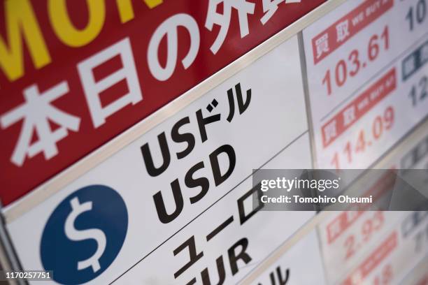 Sign listing the exchange rate of the U.S. Dollar against Japanese yen is displayed outside a currency exchange store on August 26, 2019 in Tokyo,...