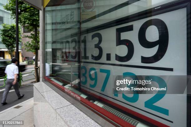 Pedestrian walks past an electronic stock board displaying the Nikkei 225 Stock Average figure on August 26, 2019 in Tokyo, Japan. Japanese stocks...