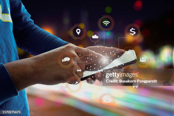 close-up image of male hands using smartphone at night on city shopping street, searching or social networks technology concept - smartphone background stockfoto's en -beelden