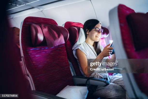 using digital tablet on an airplane - plane seat stock pictures, royalty-free photos & images