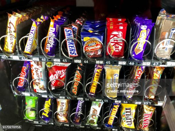 自動售貨機特寫圖片，包括巧克力棒、蛋糕和餅乾小吃 - vending machine 個照片及圖片檔