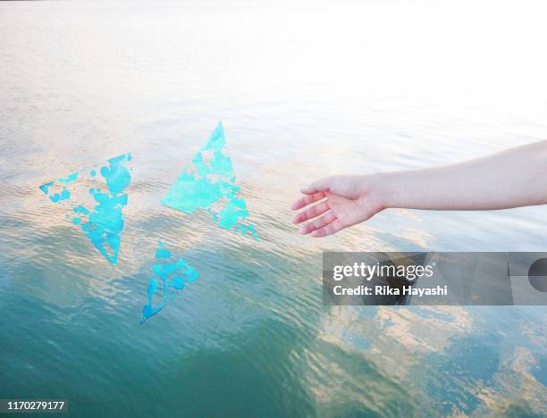 Hands stretched to the surface of the water and Triangle drawn with paint