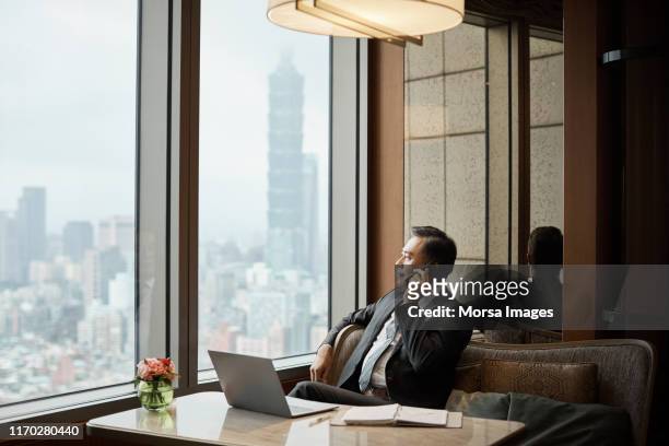 mature businessman talking on phone at restaurant - taiwan business stock pictures, royalty-free photos & images