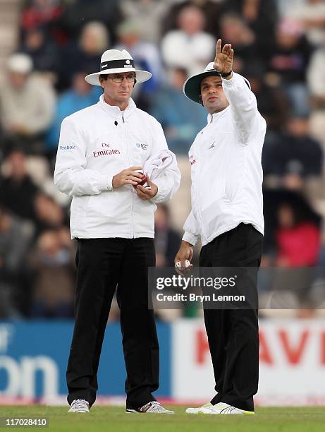 Umpire Aleem Dar points to a dark cloud over the ground with Rod Tucker during day four of the 3rd npower Test Match between England and Sri Lanka at...