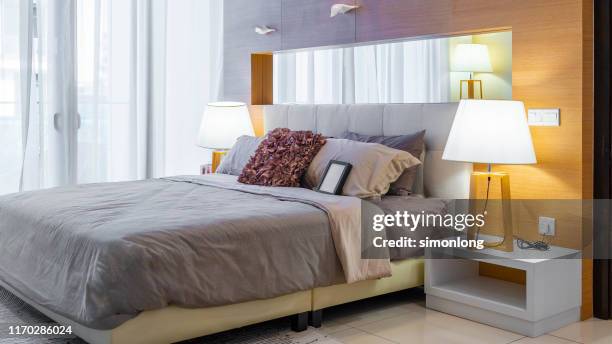 modern double bed room with illuminated table lamp - double bed stock pictures, royalty-free photos & images