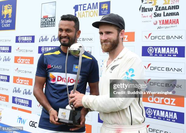 New Zealand’s caption Kane Williamson and Sri Lankan’s caption Dimuth Karunaratne pose with a trophy after the match and a 1-1 during the day five of...