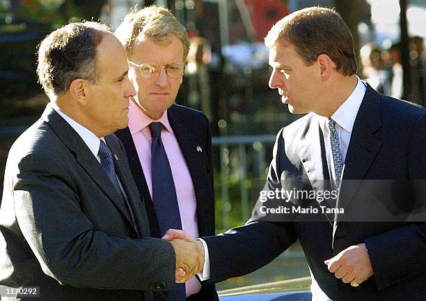 Britain's Prince Andrew shakes hands with New York Mayor Rudolph Giuliani as British Ambassador to the US Christopher Meyer looks on October 15, 2001...