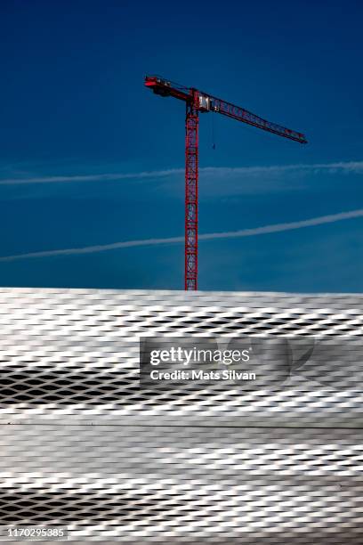 messe basel with modern facade and construction crane against blue sky - basel sommer stock-fotos und bilder