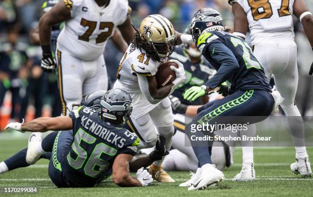 Running back Alvin Kamara of the New Orleans Saints rushes teh ball as linebacker Mychal Kendricks of the Seattle Seahawks and defensive back Tre...