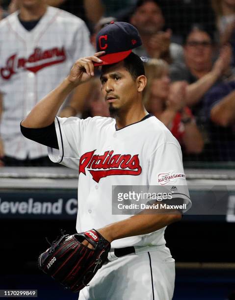 Carlos Carrasco of the Cleveland Indians tips his hat to the crowd as he returns to the dugout after getting J.T. Realmuto of the Philadelphia...