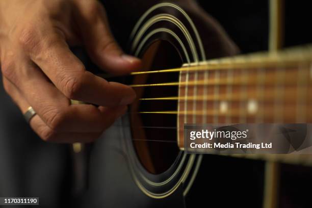 primer plano de manos humanas y parte de la guitarra - musical instrument string fotografías e imágenes de stock