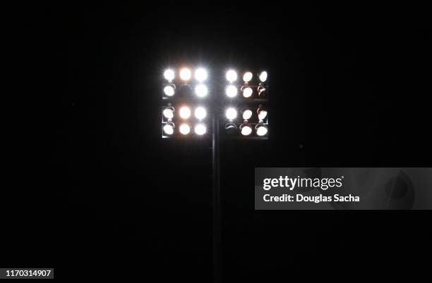 illuminated stadium lights on a dark sky - strålkastarljus bildbanksfoton och bilder