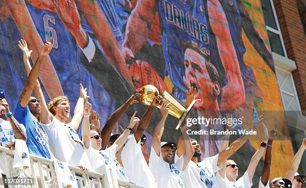 Guard Jason Kidd of the Dallas Mavericks hoists the Larry O'Brien Trophy with his teammates during the Dallas Mavericks Victory Parade on June 16,...