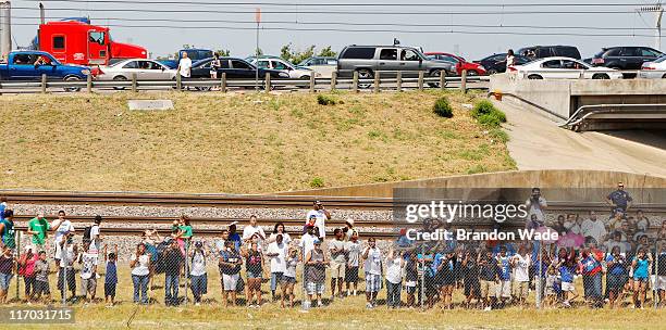 Fans gather near the Trinity Railway Express tracks on stop on Interstate 35E during the Dallas Mavericks Victory Parade on June 16, 2011 in Dallas,...