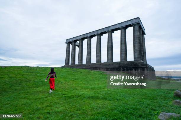 one female adault vivit the national monument of scotland in the morning - calton hill stock pictures, royalty-free photos & images